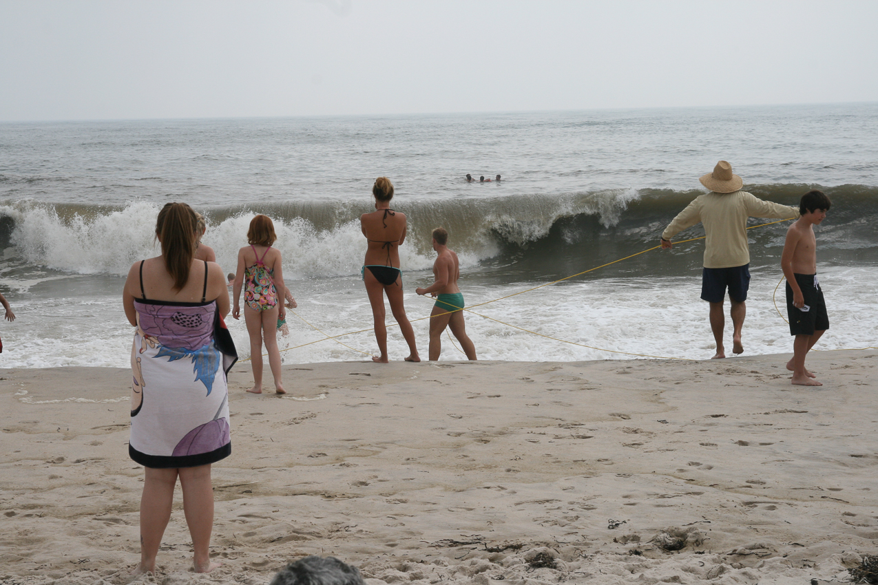 8 lifeguards pulling in a bunch of swimmers who drifted out in the rip.  ~~  