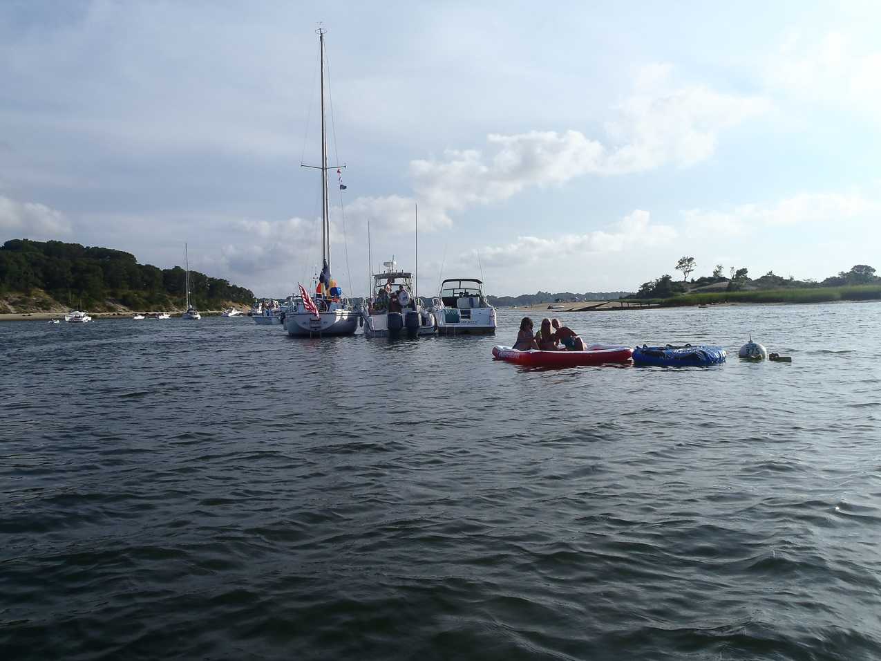 Tough life?  ~~  Gret and some of her buds in the water raft.  Our boats moored in the background.