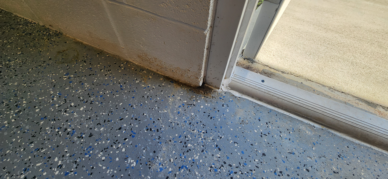 Storage East significant water aound the buidling: US Coast Guard Venice Mission Support & Training Center September 2025  ~~  Storage Building Roof and Door leaks